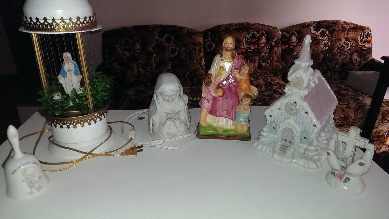 Mary lamps, Jesus statue with kids, church and cross decorations, and a bell