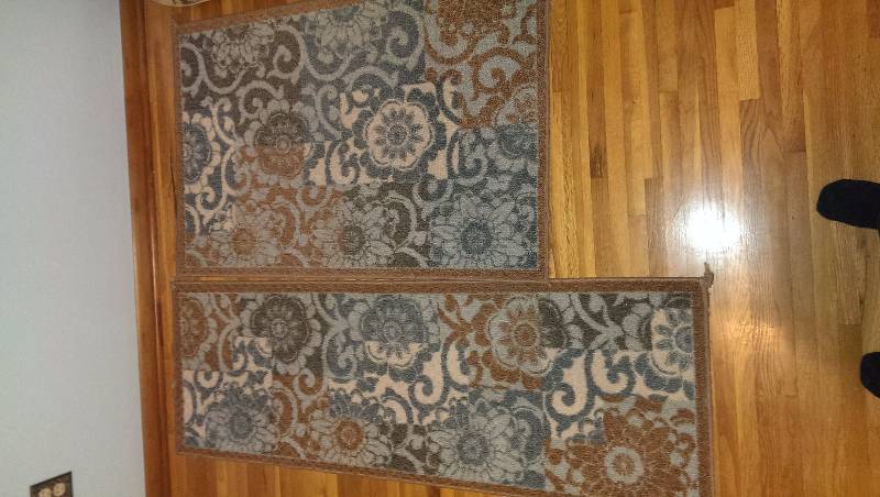 Two matching rugs, rectangular with teal and brown