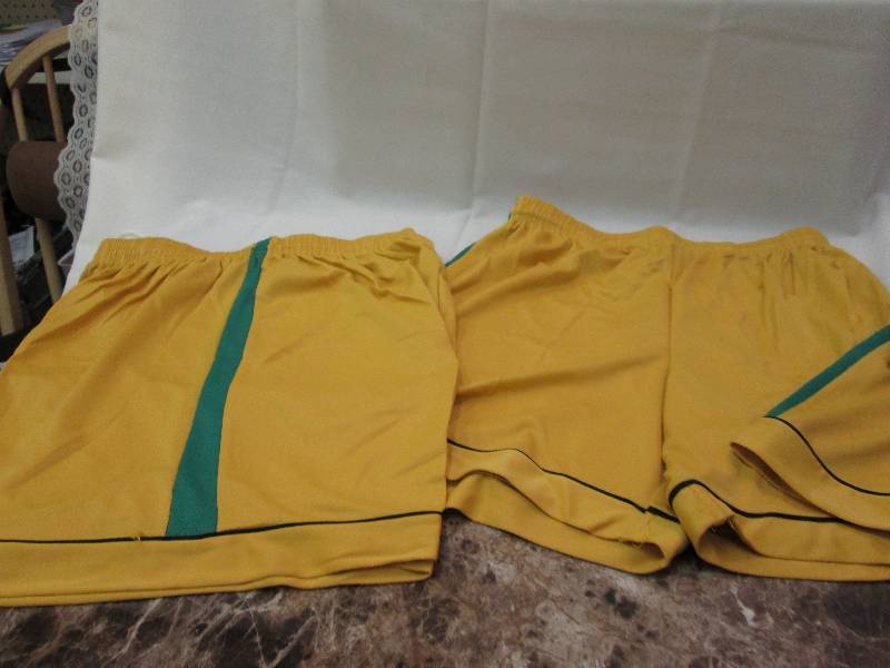 Gold shorts with green and black ac...