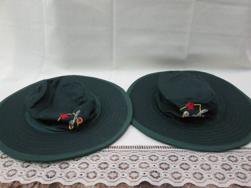 2 green hats with logo on front...