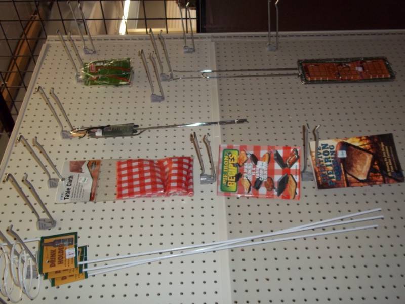 lot 125 image: Wall Shelf of Camping Supplies includes Drink Holders, Cookbooks, Table Cloths etc