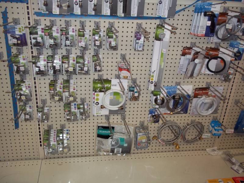 lot 211 image: Wall Shelf Lot Bottom Half includes shut off valves, supply lines, sprayer hoses, etc