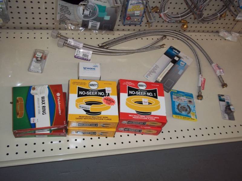 lot 212 image: 4 ft Shelf Lot includes wax rings, toilet connector hoses, etc